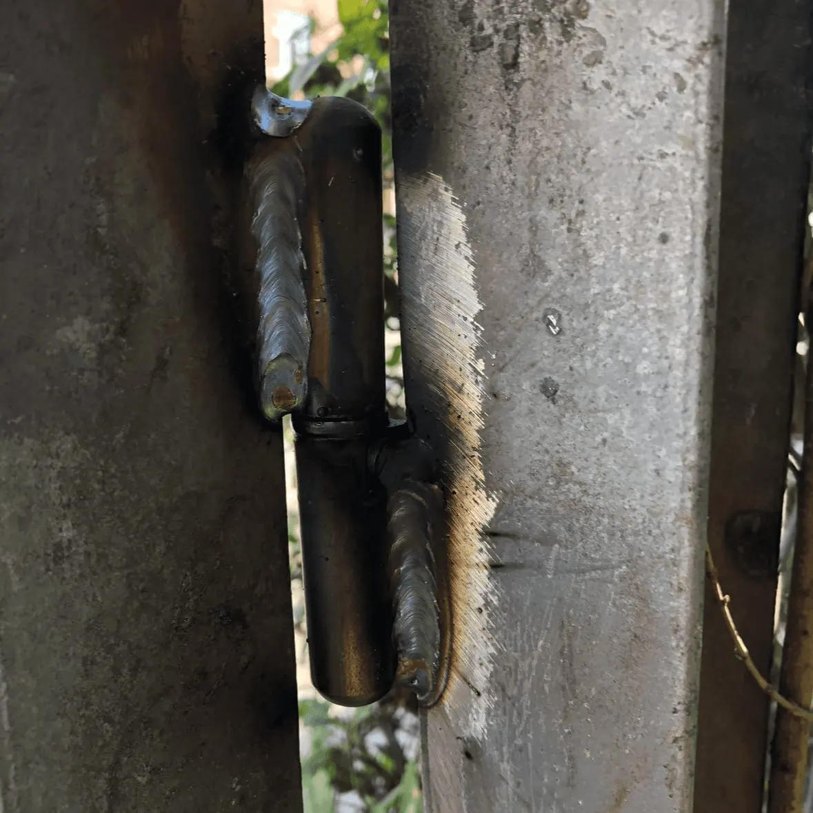 Hinge welded to a post